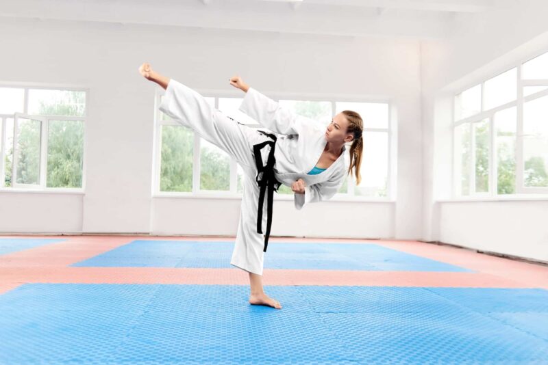 Sporty karate woman against big window standing in karate position